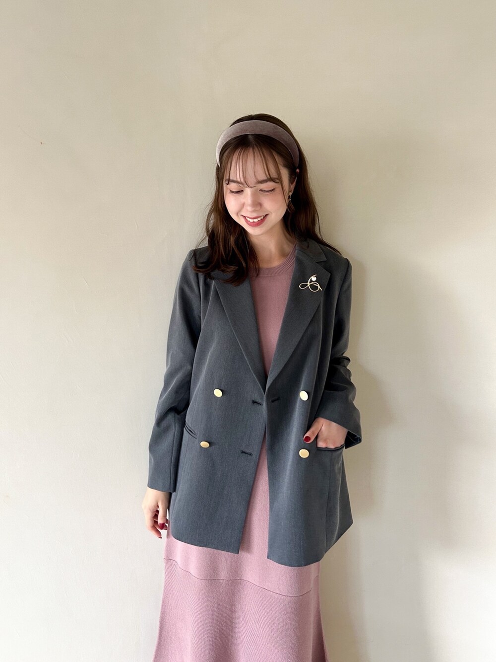 ピンク系のワンピース、グレー系のテーラードジャケット、ホワイト系のブーツを着用したレディースの秋コーディネートの3枚目の写真