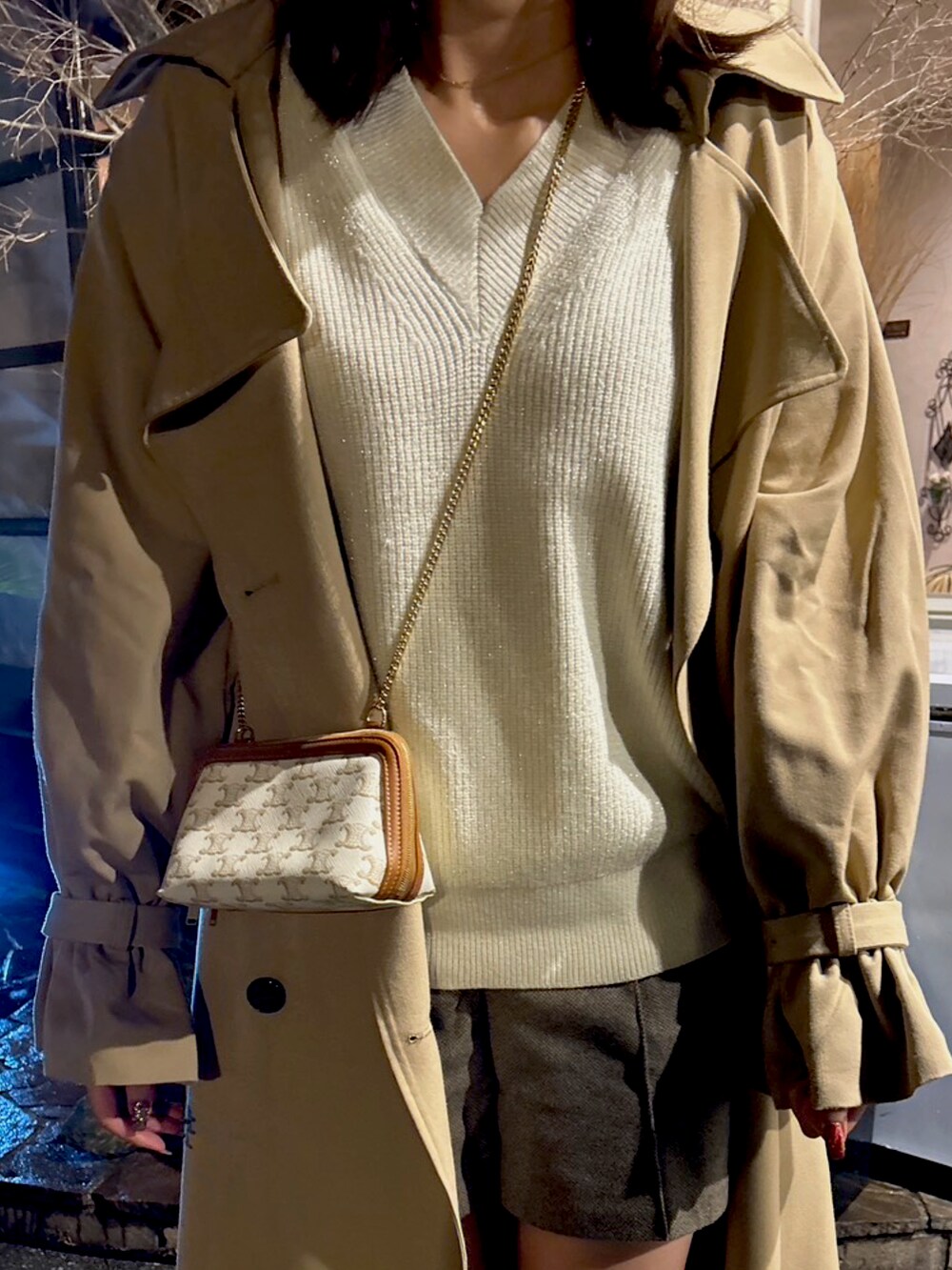ベージュ系のトレンチコート、ホワイト系のニット/セーター、ホワイト系のショルダーバッグを着用したレディースの冬コーディネートの2枚目の写真