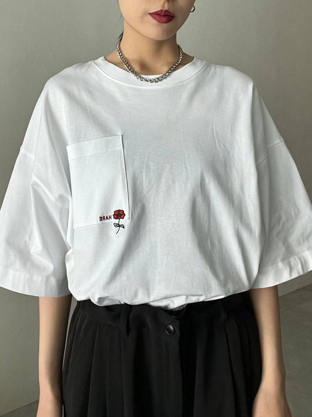 ブラック系のサンダル、ホワイト系のTシャツ/カットソー、ブラック系のスラックスを着用したレディースの春コーディネートの2枚目の写真