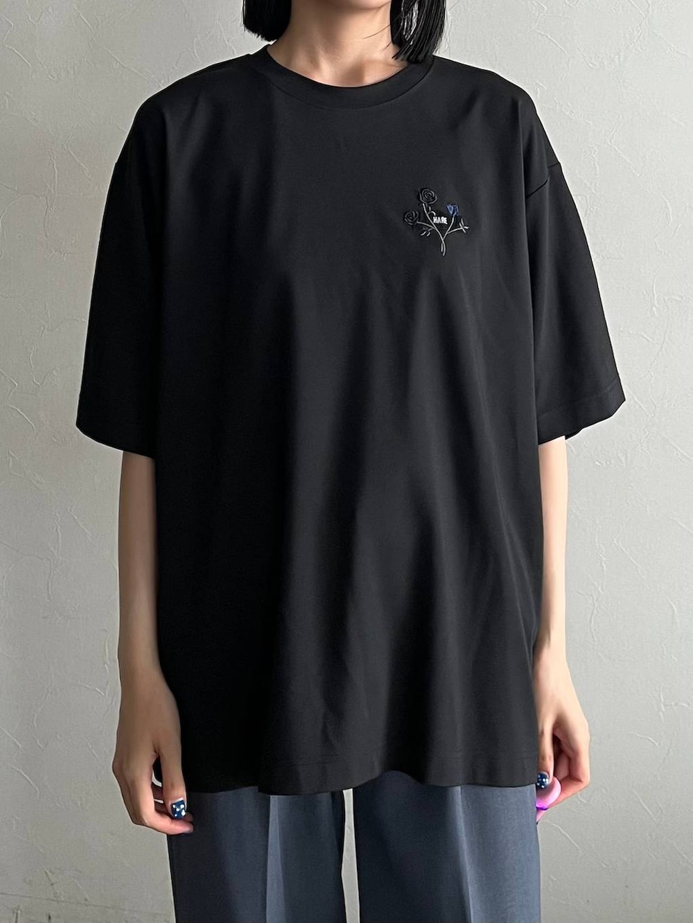 ブラック系のTシャツ/カットソー、ブラック系のローファー、ブルー系のスラックスを着用したレディースの夏コーディネートの2枚目の写真