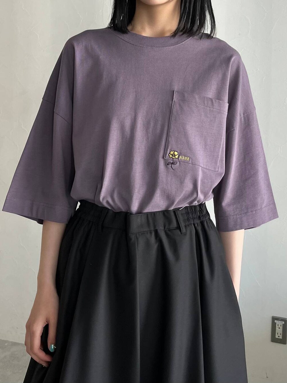 ブラック系のスラックス、ブラック系のサンダル、パープル系のTシャツ/カットソーを着用したレディースの春コーディネートの2枚目の写真