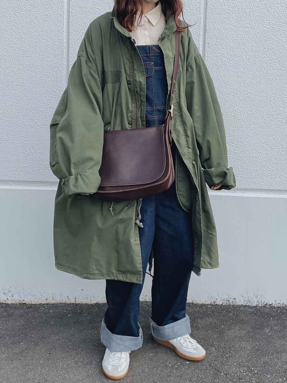 ブルー系のサロペット/オーバーオール、ベージュ系のシャツ/ブラウス、ブラウン系のショルダーバッグを着用したレディースの春コーディネートの2枚目の写真