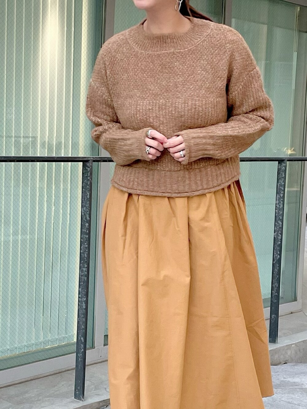 ブルー系のノーカラーコートを着用したレディースの冬コーディネートの2枚目の写真