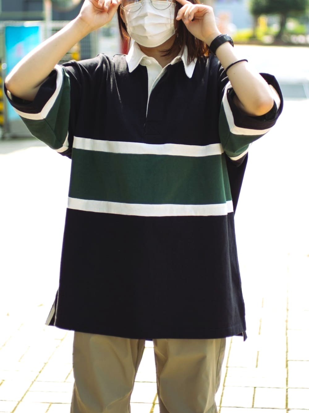 ブラック系のポロシャツを着用したレディースの夏コーディネートの2枚目の写真