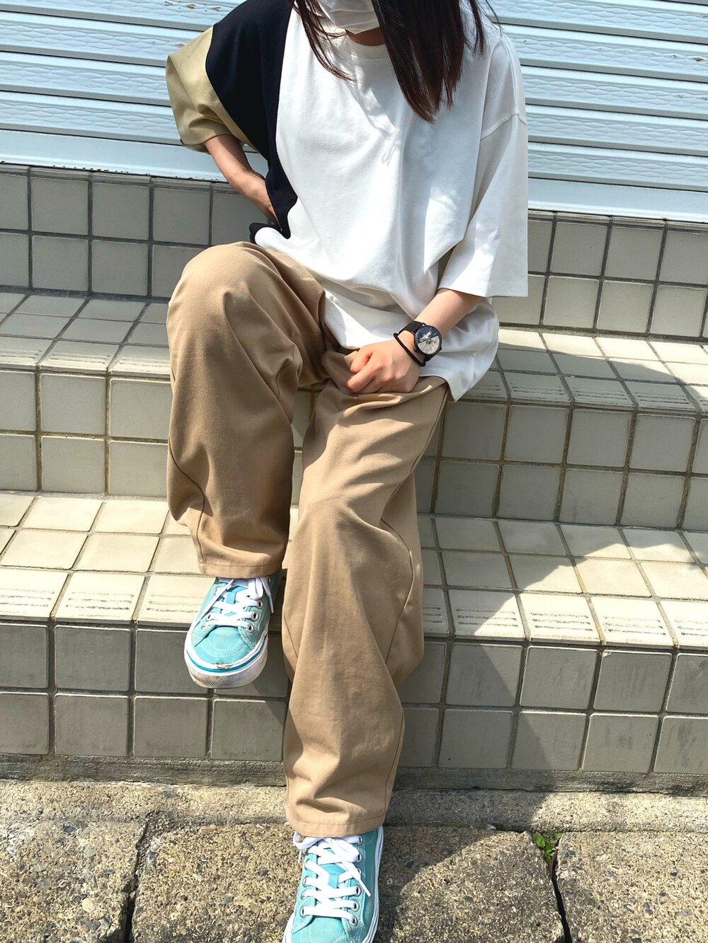 ベージュ系のスラックスを着用したレディースの夏コーディネートの2枚目の写真