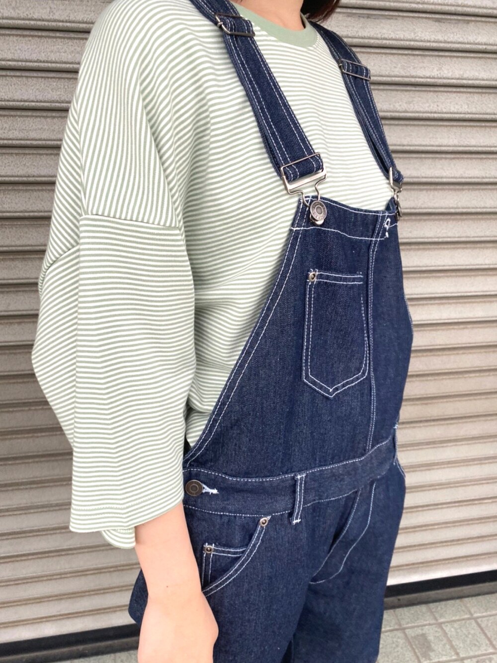 グリーン系のTシャツ/カットソー、ブルー系のサロペット/オーバーオールを着用したレディースの春コーディネートの2枚目の写真