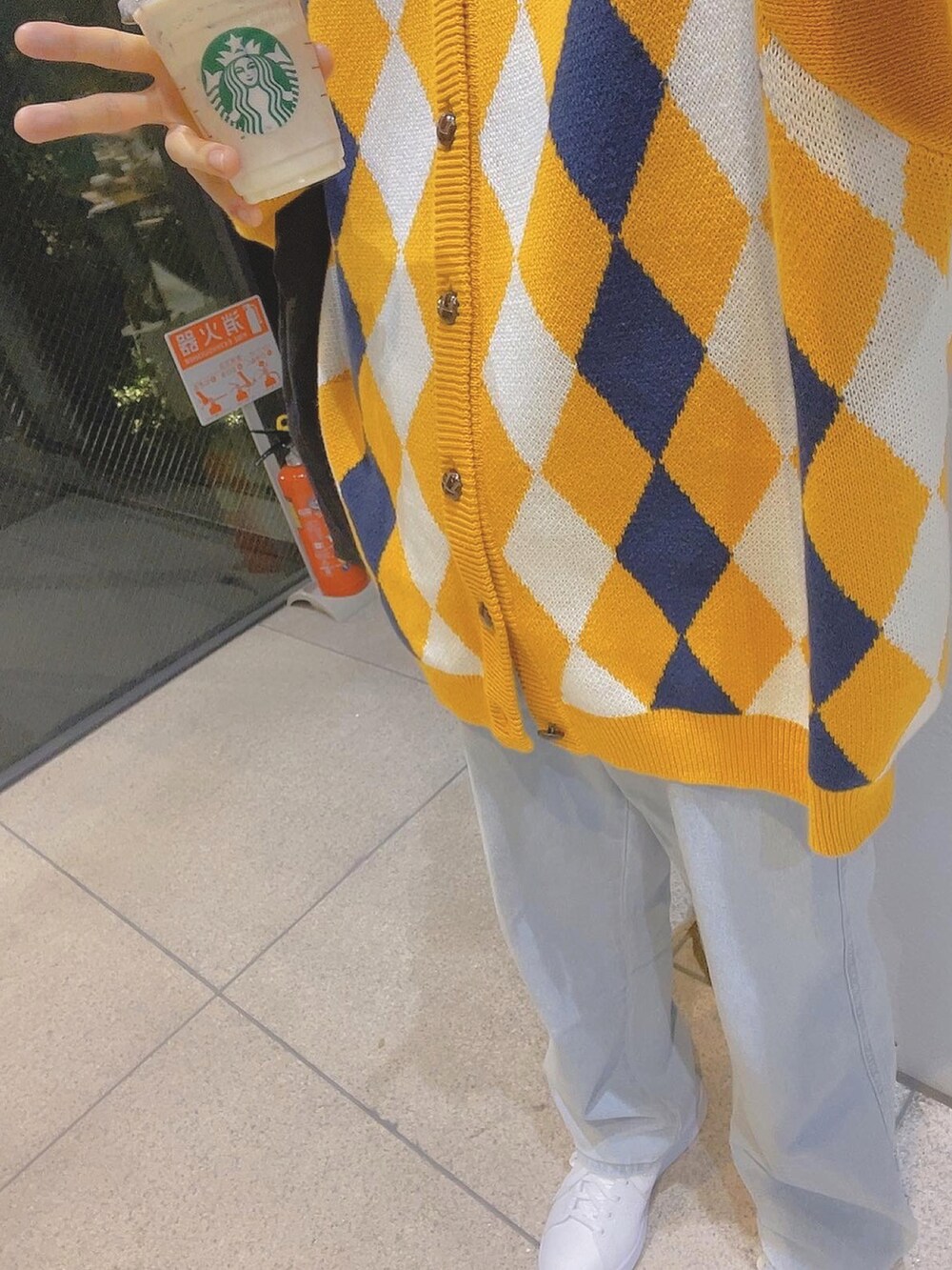 ホワイト系のスニーカー、ブルー系のデニムパンツ、イエロー系のカーディガン/ボレロを着用したメンズの春コーディネートの2枚目の写真