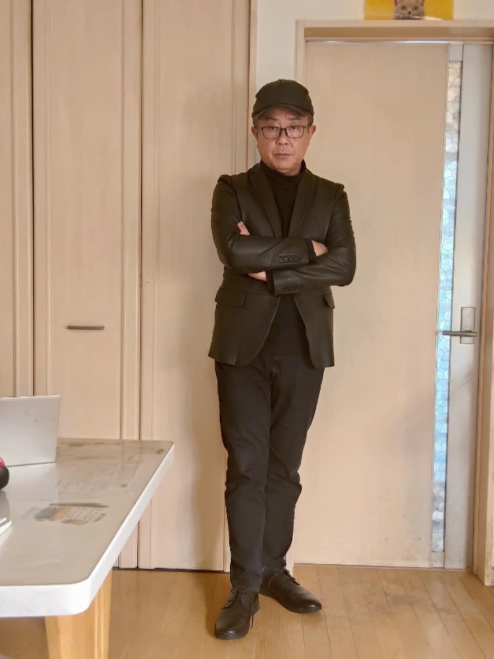 ブラック系のテーラードジャケット、ブラック系のデニムパンツ、ブラック系のスニーカーを着用したメンズの秋コーディネートの3枚目の写真