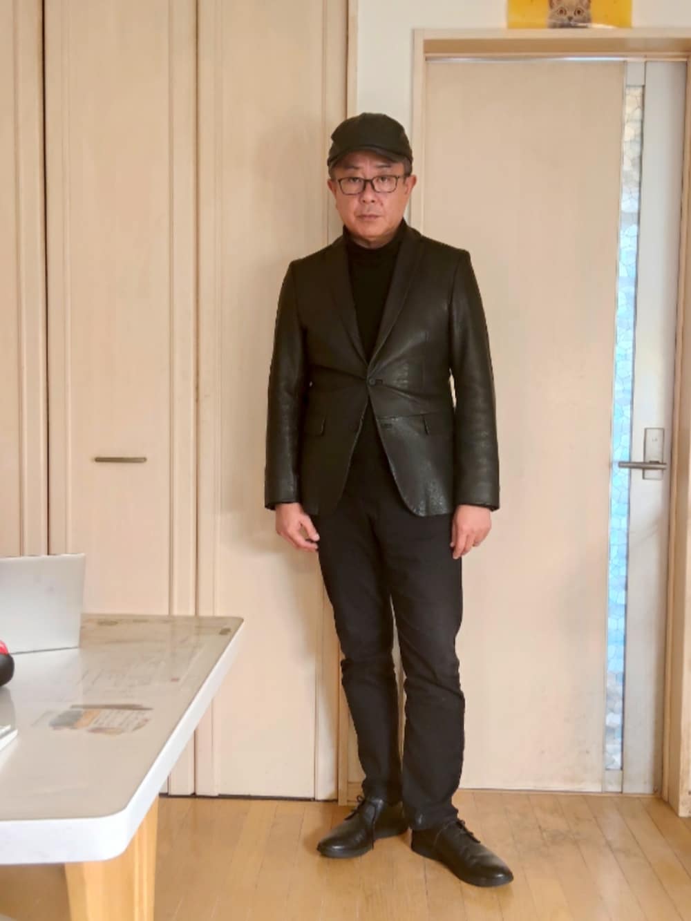 ブラック系のテーラードジャケット、ブラック系のデニムパンツ、ブラック系のスニーカーを着用したメンズの秋コーディネートの2枚目の写真