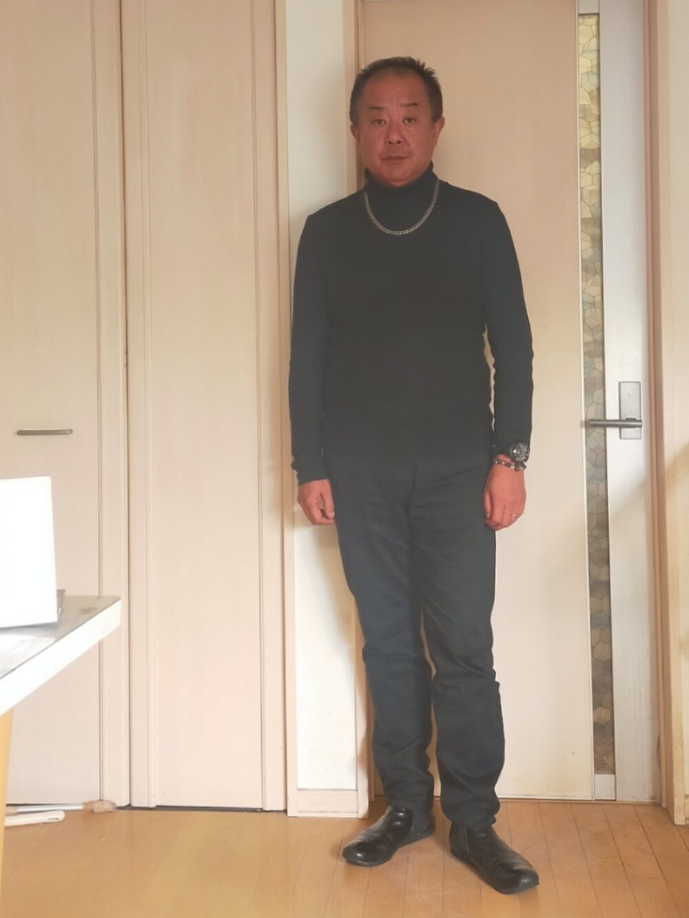 ブラック系のニット/セーター、ブラック系のデニムパンツ、ブラック系のブーツを着用したメンズの冬コーディネートの2枚目の写真