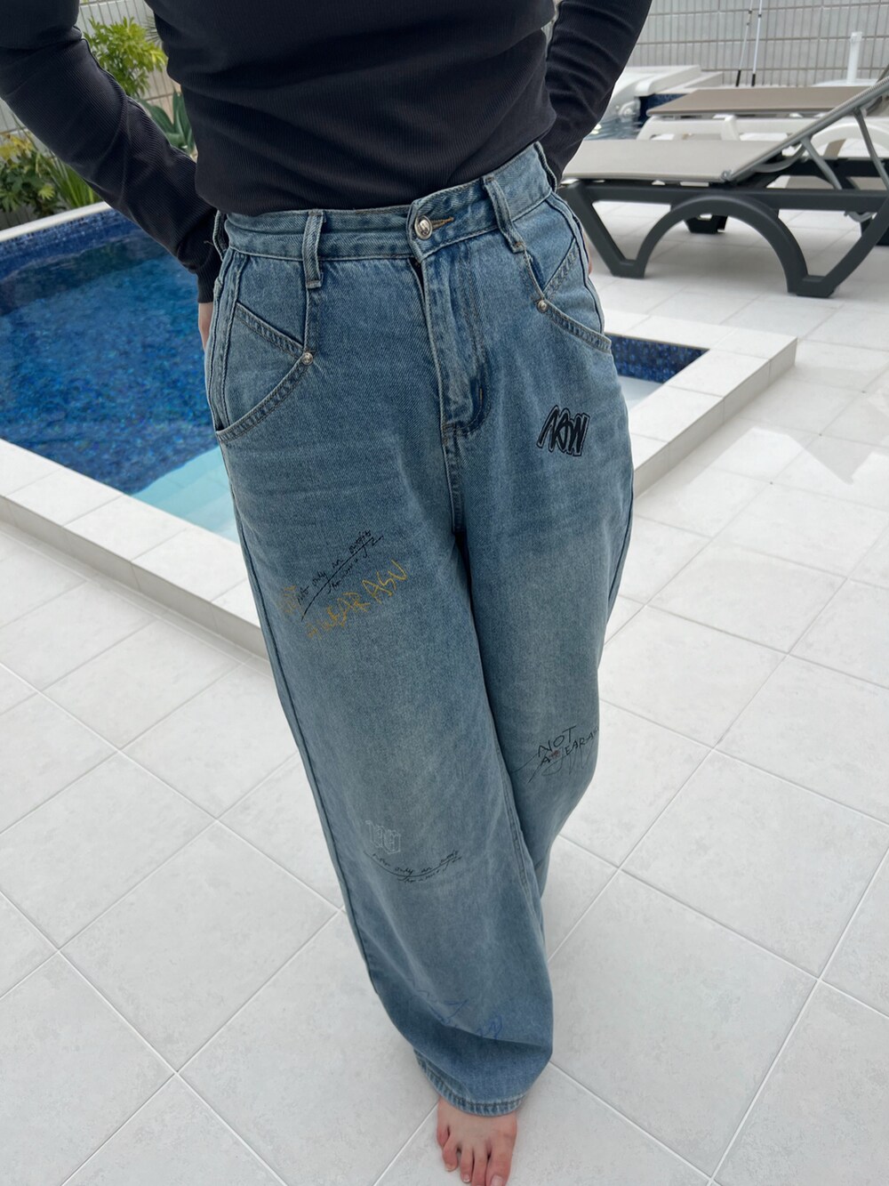 ブルー系のデニムパンツ、グレー系のTシャツ/カットソー、ブラック系のサンダルを着用したレディースの春コーディネートの3枚目の写真