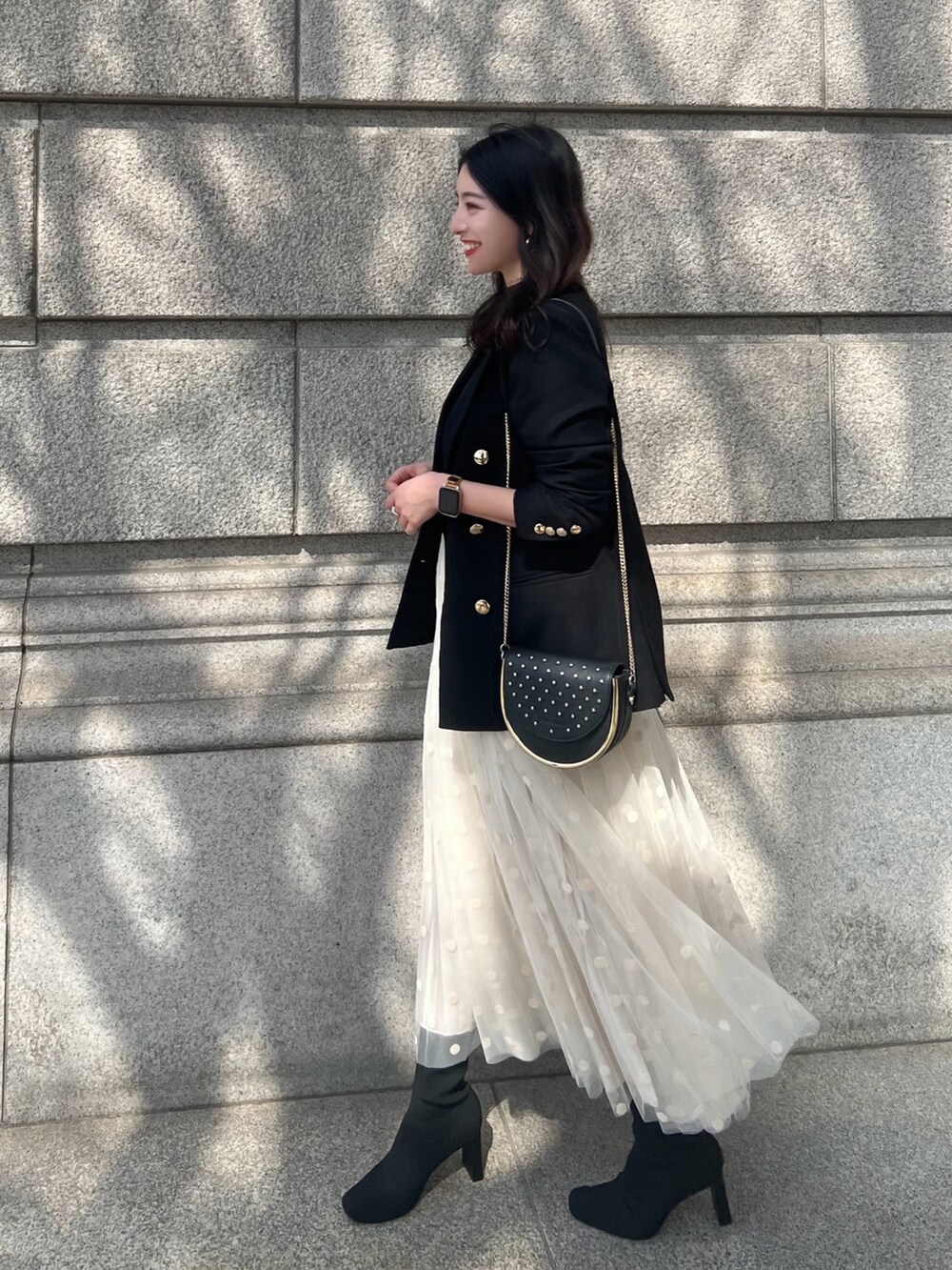ホワイト系のスカート、ブラウン系のTシャツ/カットソー、ブラック系のブーツを着用したレディースの春コーディネートの2枚目の写真