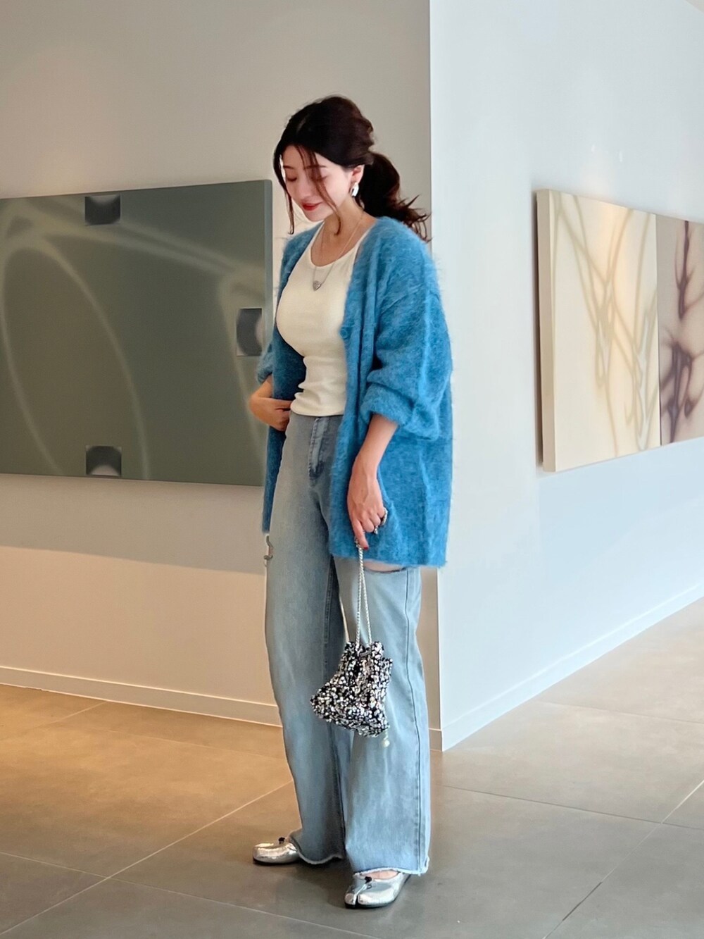 ブルー系のカーディガン/ボレロ、シルバー系のショルダーバッグ、シルバー系のパンプスを着用したレディースの秋コーディネートの2枚目の写真