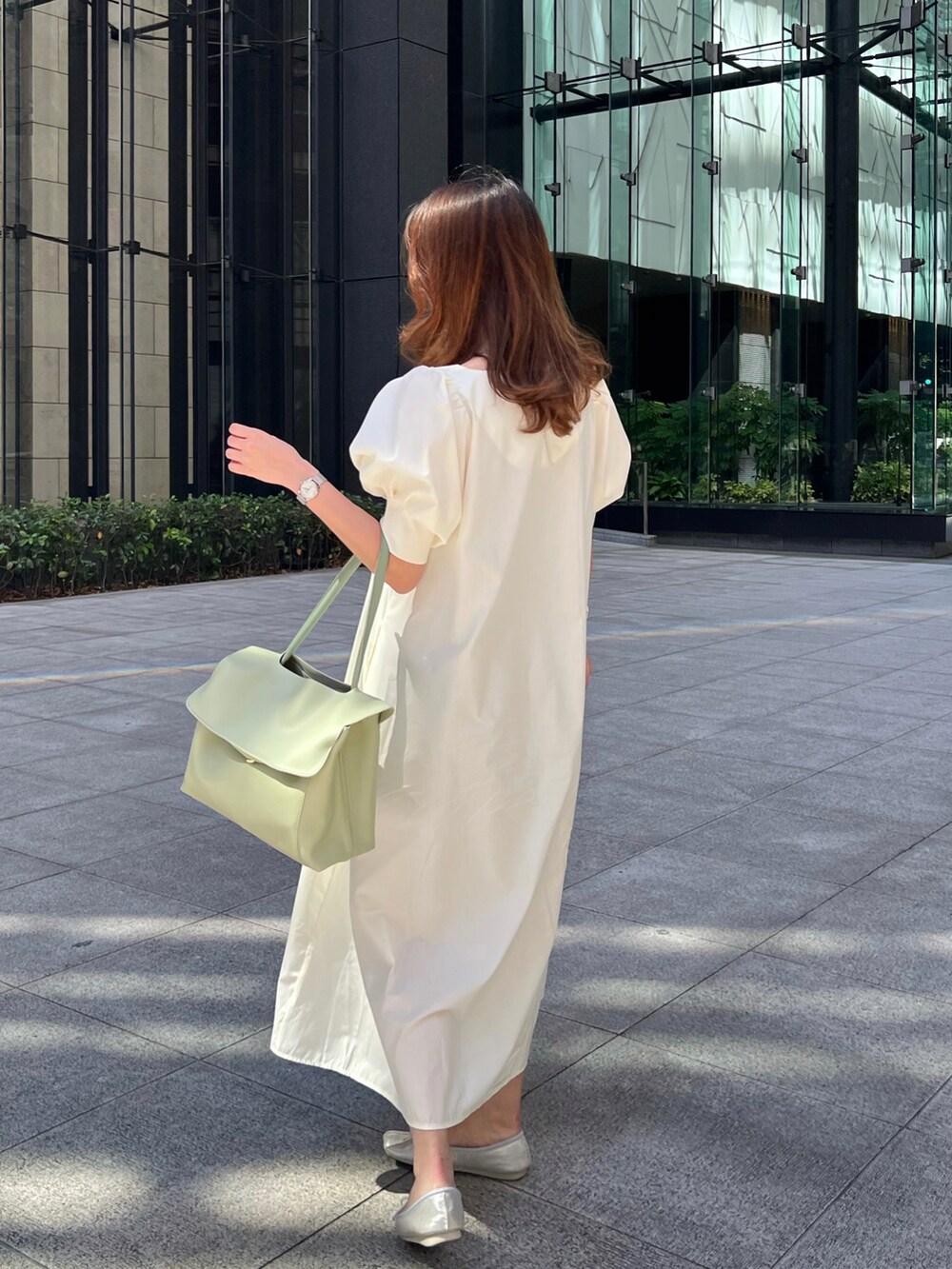 ホワイト系のショルダーバッグ、ホワイト系のワンピース、シルバー系のバレエシューズを着用したレディースの春コーディネートの2枚目の写真