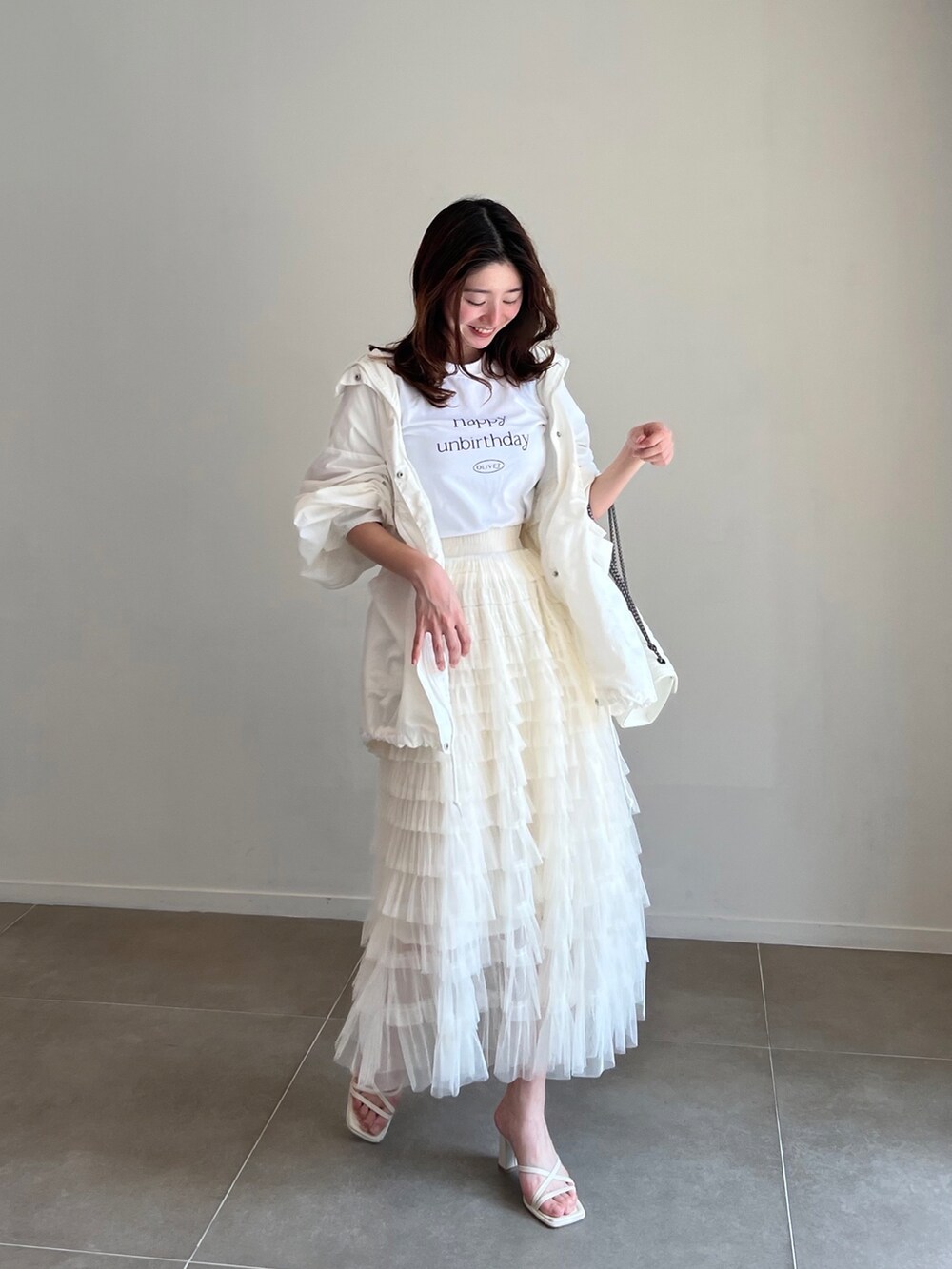 ホワイト系のTシャツ/カットソー、ホワイト系のモッズコート、ホワイト系のスカートを着用したレディースの春コーディネートの2枚目の写真