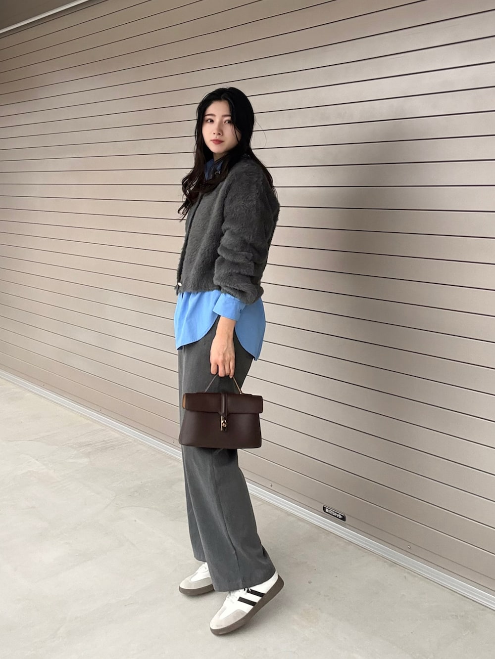 グレー系のカーディガン/ボレロ、ブラウン系のショルダーバッグを着用したレディースの冬コーディネートの2枚目の写真