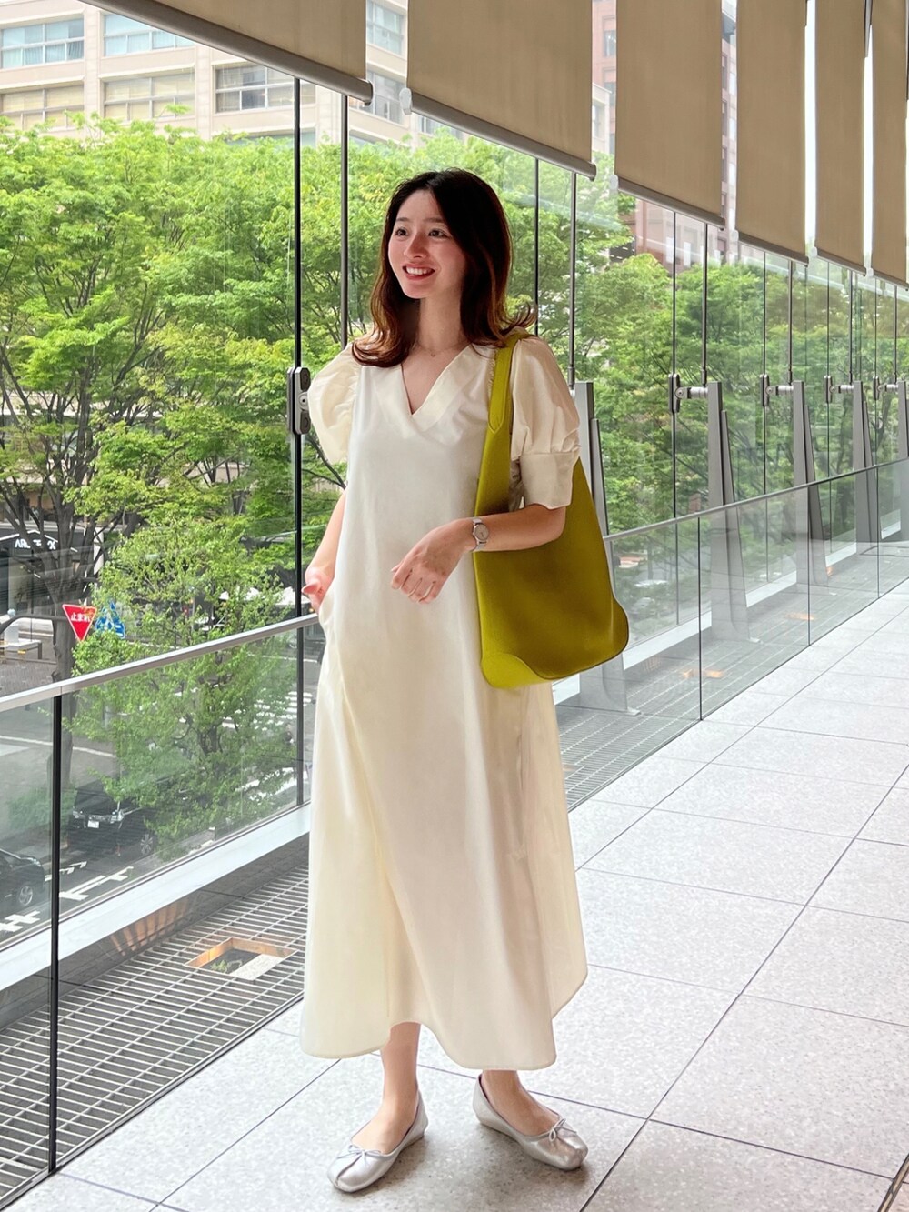 ホワイト系のワンピース、グリーン系のトートバッグ、シルバー系のバレエシューズを着用したレディースの春コーディネートの2枚目の写真