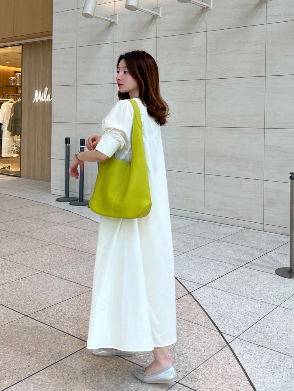 ホワイト系のワンピース、グリーン系のトートバッグ、シルバー系のバレエシューズを着用したレディースの春コーディネートの3枚目の写真