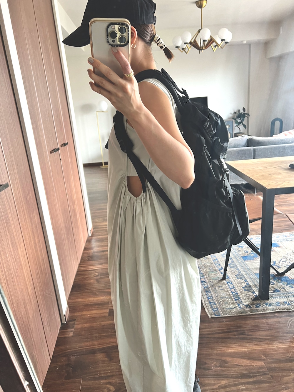 ホワイト系のワンピース、ブラック系のバックパック/リュック、ブラック系のスニーカーを着用したレディースの夏コーディネートの3枚目の写真