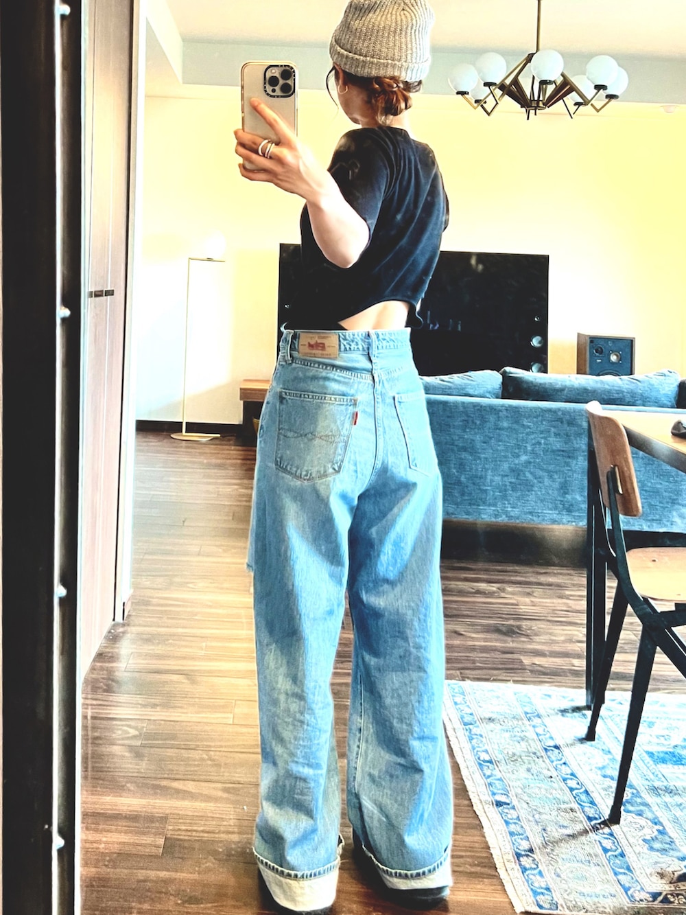 ブルー系のデニムパンツ、ブラック系のTシャツ/カットソー、ブラック系のハンドバッグを着用したレディースの夏コーディネートの3枚目の写真