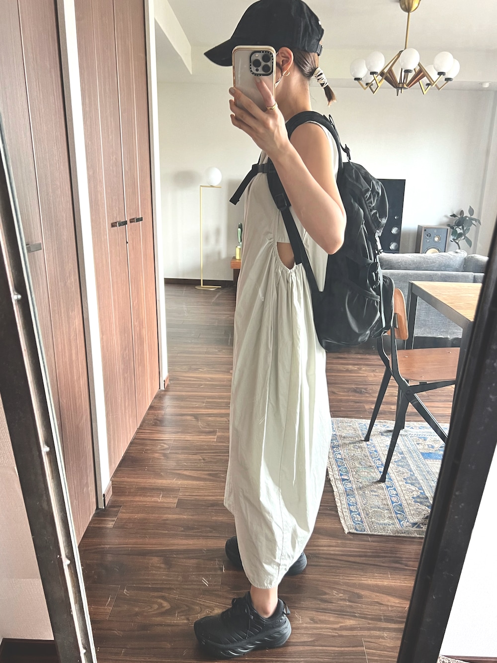 ホワイト系のワンピース、ブラック系のバックパック/リュック、ブラック系のスニーカーを着用したレディースの夏コーディネートの2枚目の写真