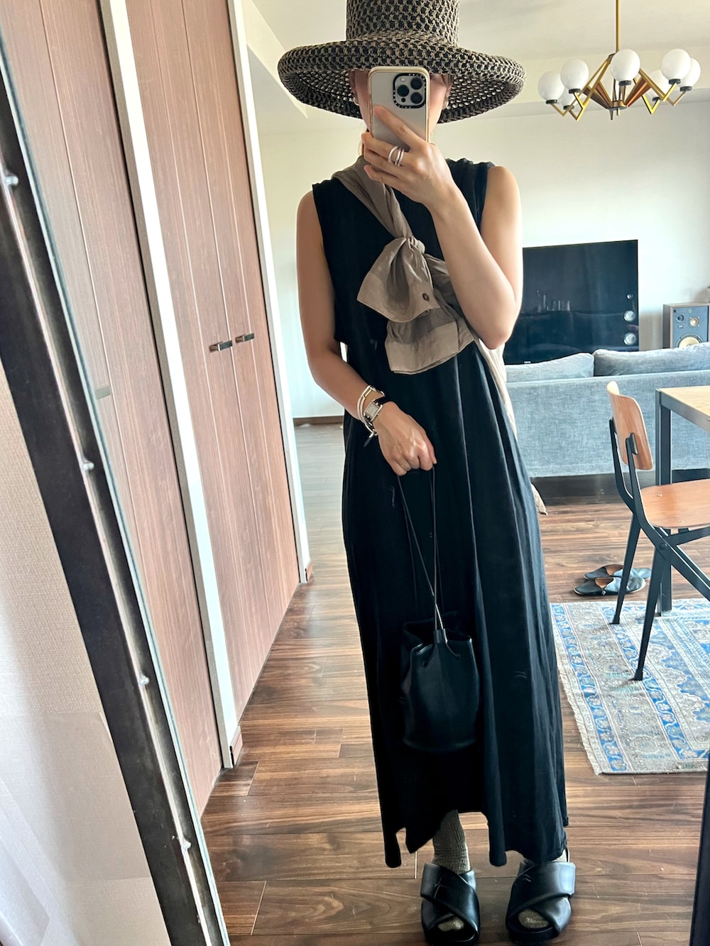 ブラック系のハンドバッグ、ブラック系のサンダル、ブラウン系のシャツ/ブラウスを着用したレディースの夏コーディネートの2枚目の写真