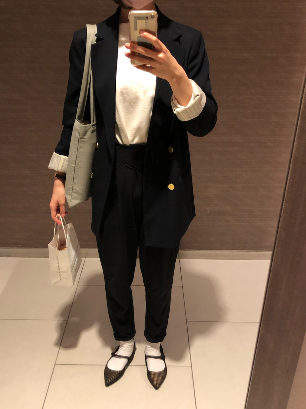 ブラウン系のその他シューズ、ブルー系のテーラードジャケット、グリーン系のトートバッグを着用したレディースの秋コーディネートの2枚目の写真