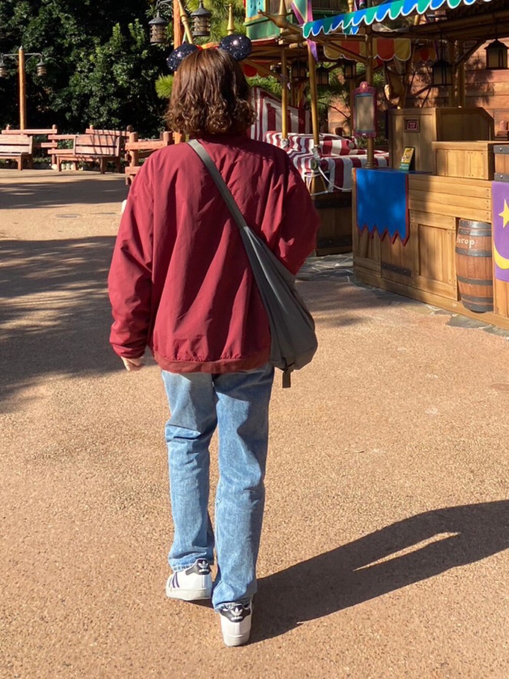 レッド系のその他アウター、ホワイト系のスニーカー、ブルー系のデニムパンツを着用したレディースの冬コーディネートの2枚目の写真