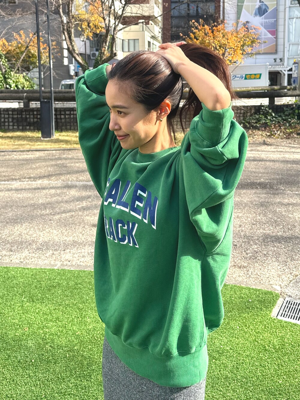 グリーン系のスウェット、グレー系のスカートを着用したレディースの冬コーディネートの6枚目の写真