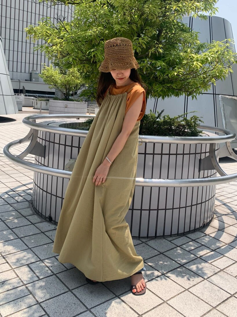 ブルー系のデニムパンツ、グリーン系のワンピース、ブラウン系のサンダルを着用したレディースの夏コーディネートの3枚目の写真