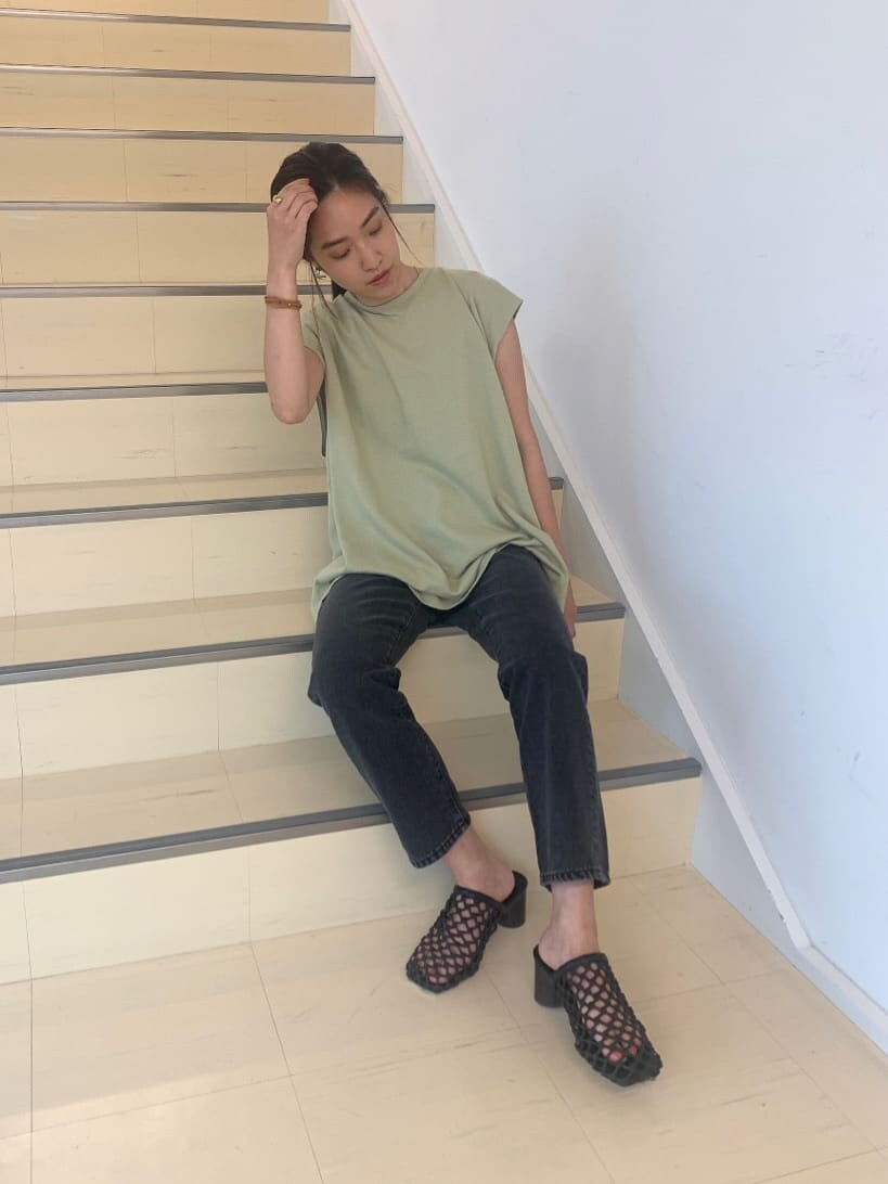 ブラック系のサンダル、ブラック系のデニムパンツ、グリーン系のTシャツ/カットソーを着用したレディースの夏コーディネートの4枚目の写真
