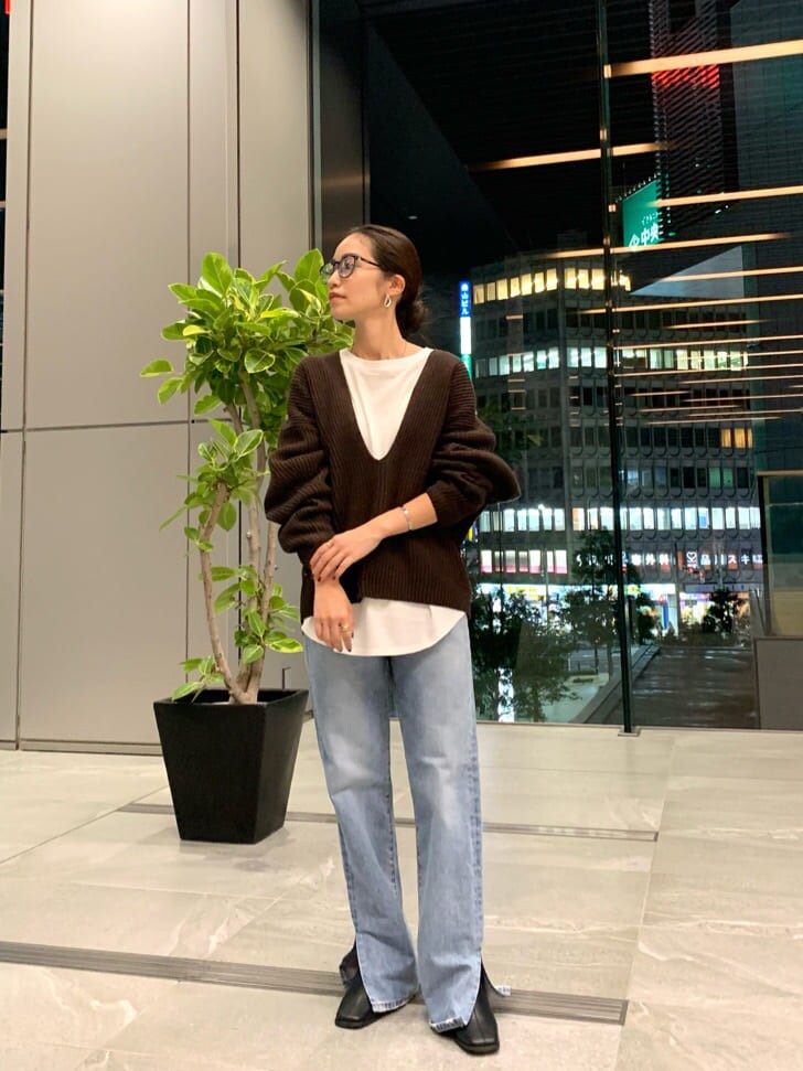 ブラック系のブーツ、ブルー系のデニムパンツ、ホワイト系のTシャツ/カットソーを着用したレディースの秋コーディネートの6枚目の写真
