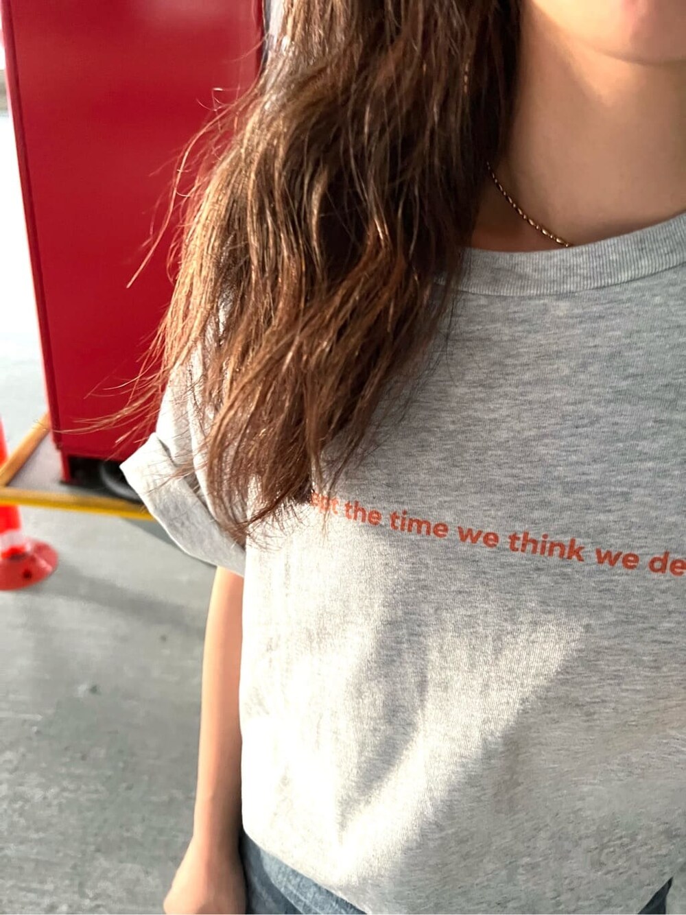 グレー系のTシャツ/カットソー、ブラック系のサンダル、ブルー系のデニムパンツを着用したレディースの春コーディネートの5枚目の写真