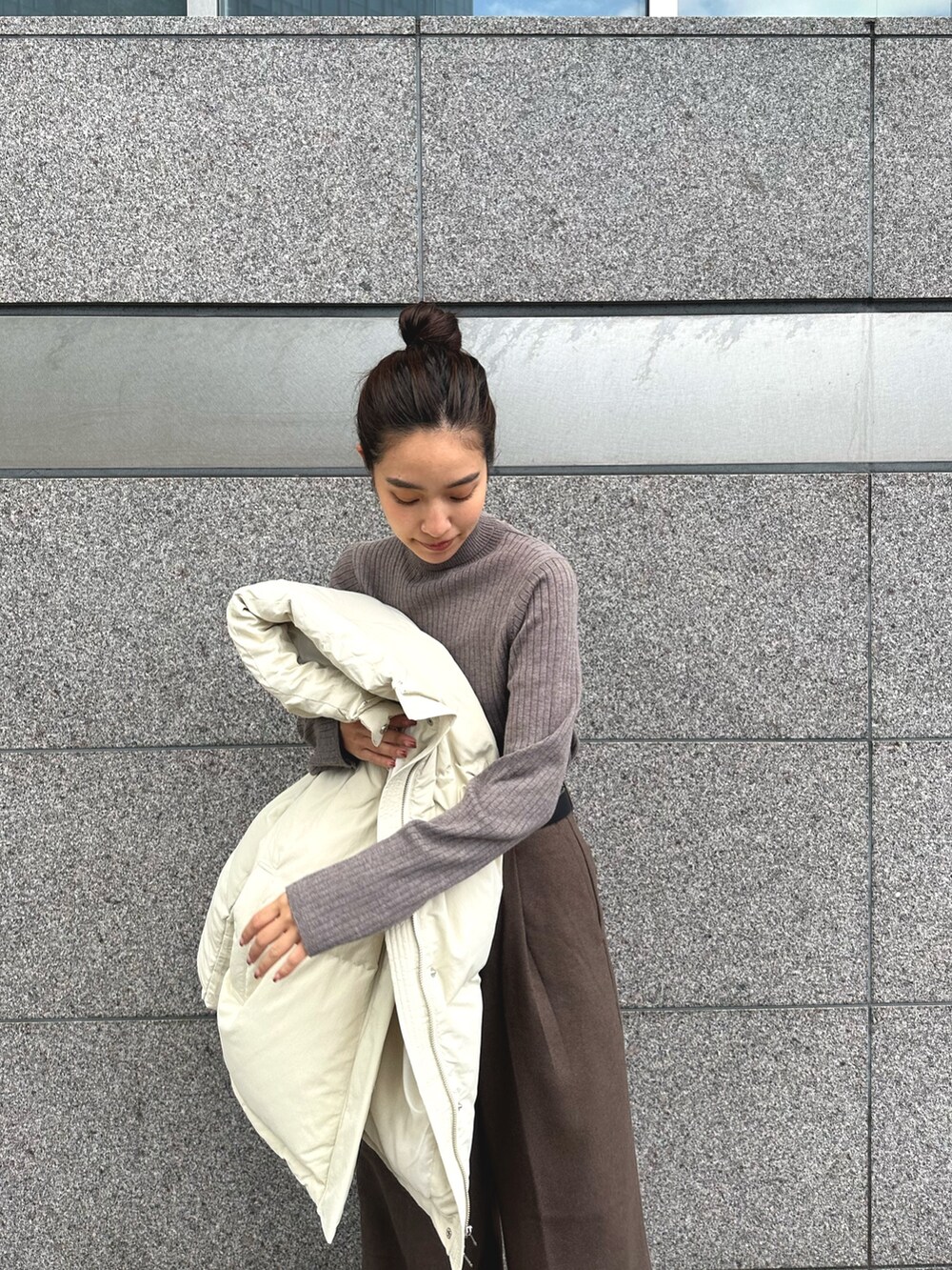 ホワイト系のダウンジャケット/コート、グレー系のニット/セーター、ブラウン系のその他パンツを着用したレディースの秋コーディネートの8枚目の写真