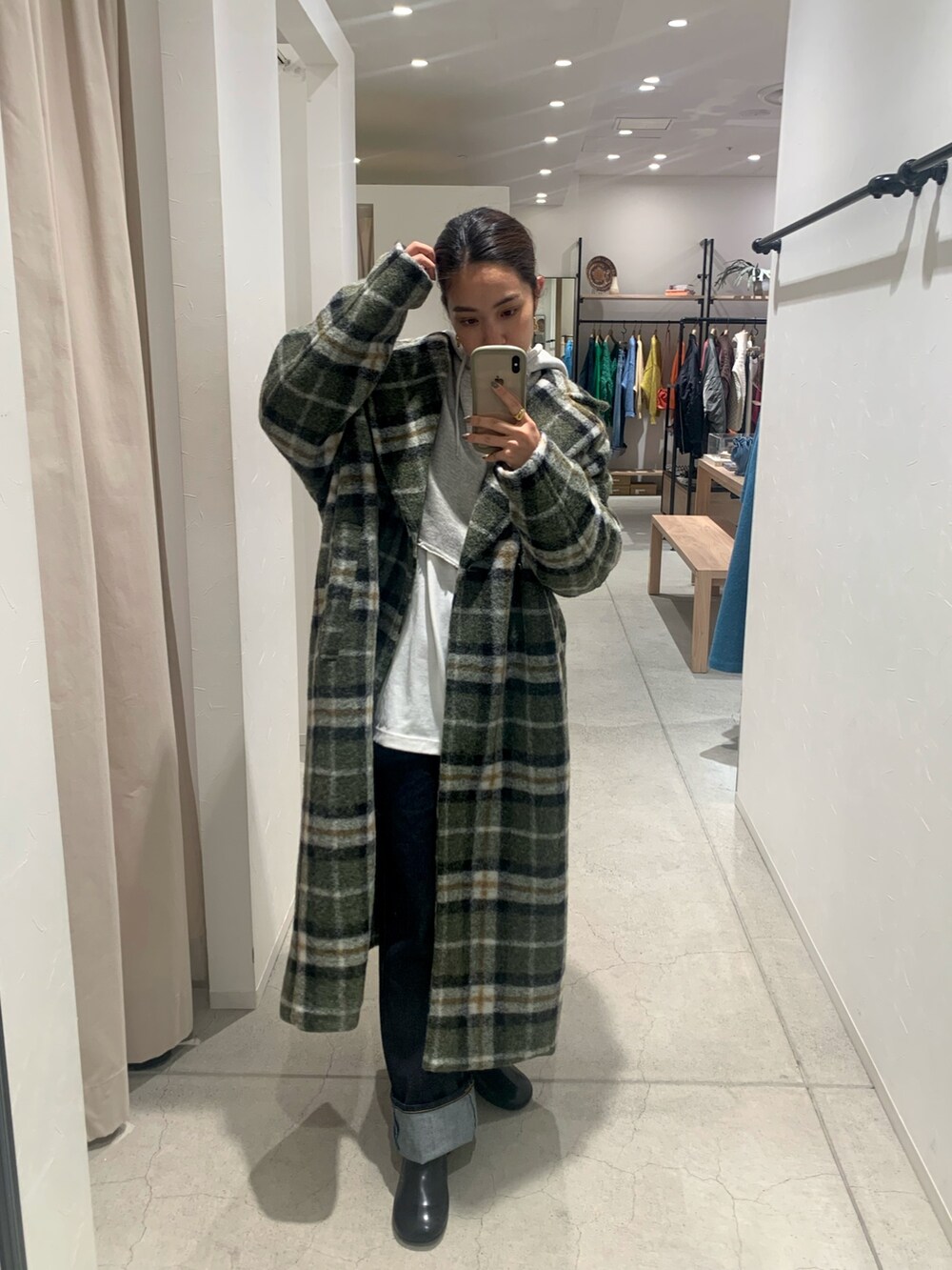 ブルー系のデニムパンツ、その他のチェスターコート、グレー系のパーカーを着用したレディースの秋コーディネートの2枚目の写真