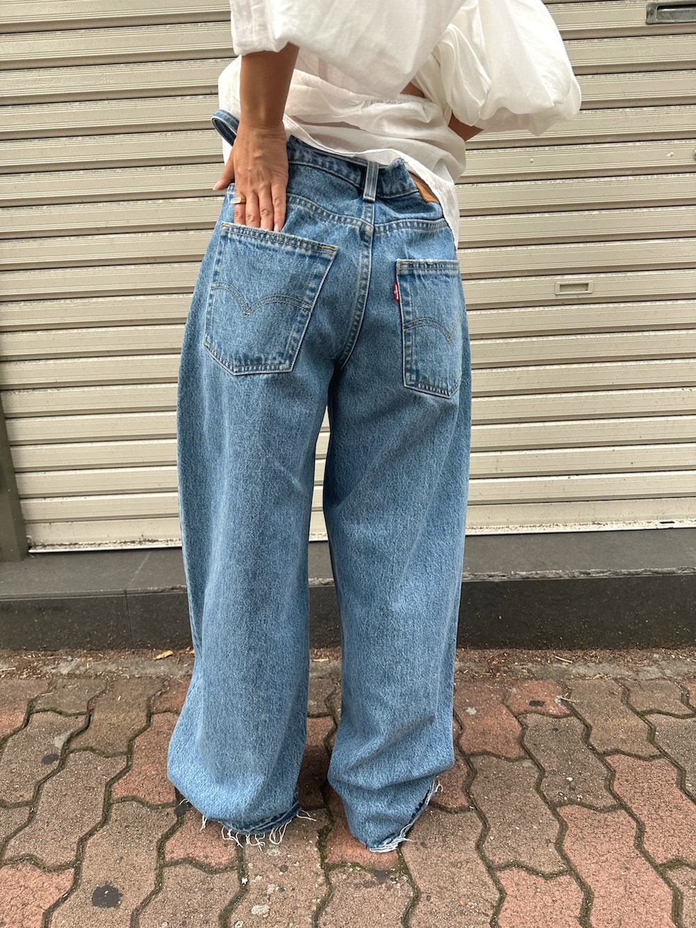 ホワイト系のシャツ/ブラウス、ブルー系のデニムパンツ、ブルー系のキャップを着用したレディースの夏コーディネートの6枚目の写真