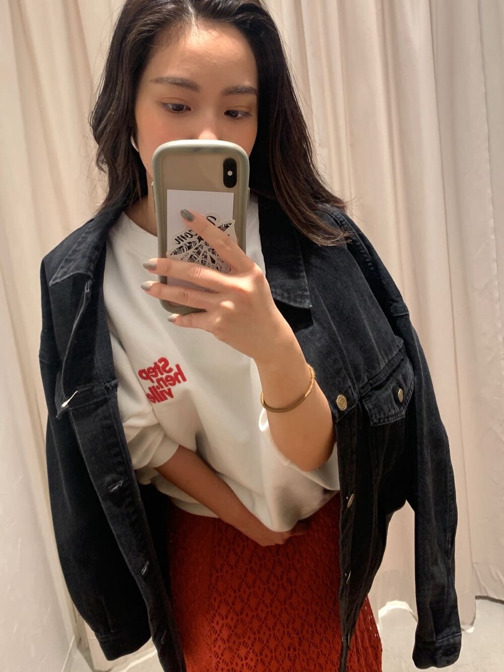 ホワイト系のスウェット、ブラック系のデニムジャケット、オレンジ系のスカートを着用したレディースの冬コーディネートの2枚目の写真