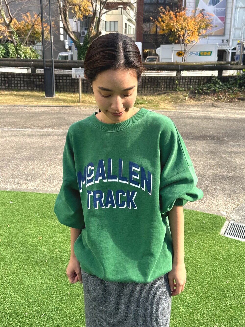 グリーン系のスウェット、グレー系のスカートを着用したレディースの冬コーディネートの5枚目の写真