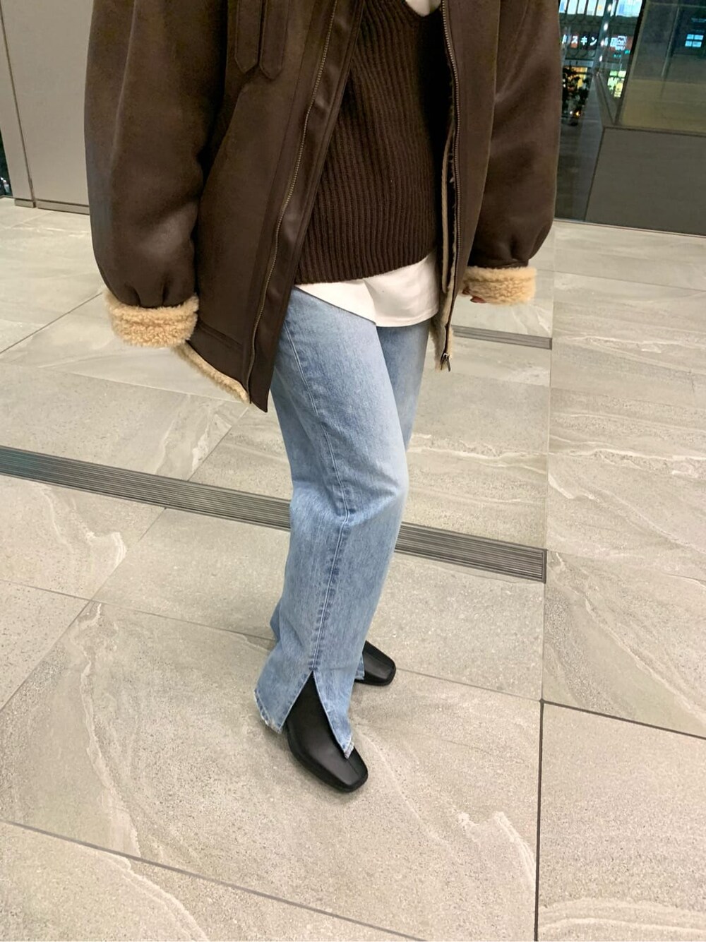 ブラック系のブーツ、ブルー系のデニムパンツ、ホワイト系のTシャツ/カットソーを着用したレディースの秋コーディネートの10枚目の写真
