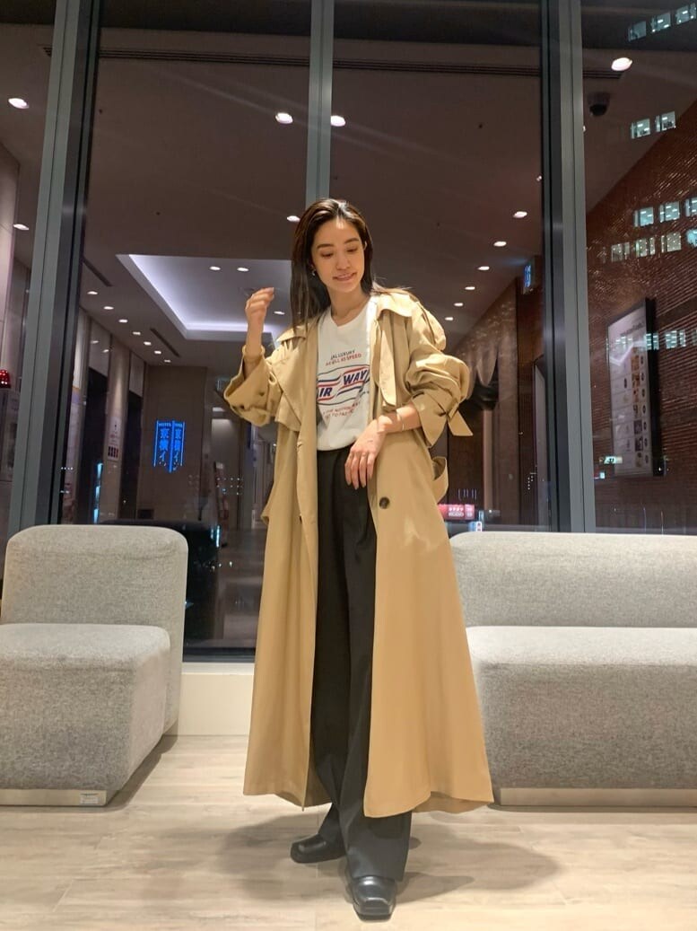 ベージュ系のトレンチコート、グレー系のスラックス、ホワイト系のTシャツ/カットソーを着用したレディースの秋コーディネートの3枚目の写真