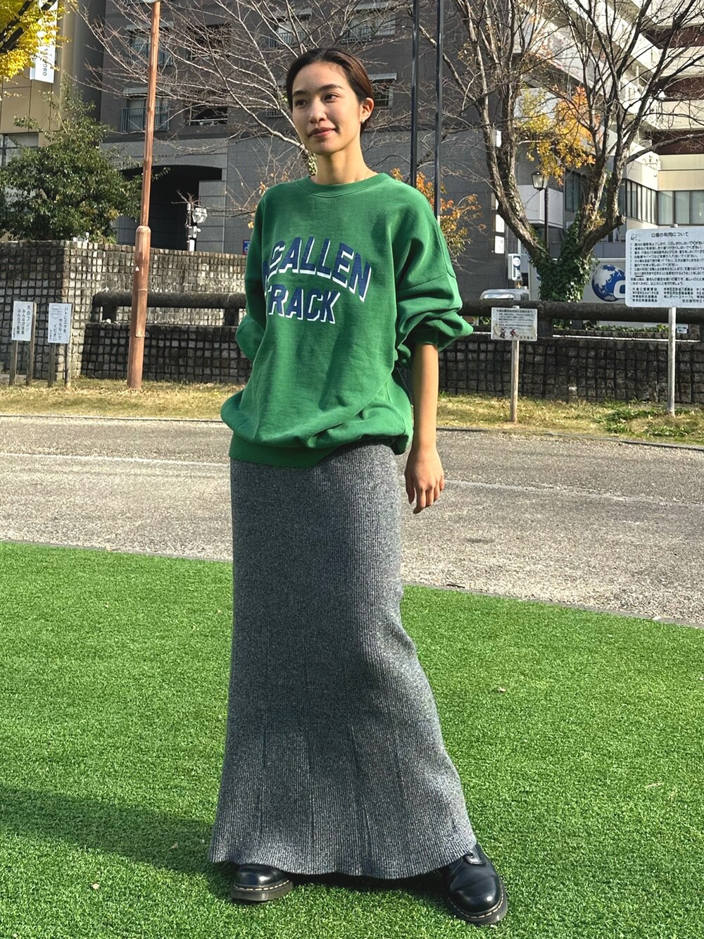 グリーン系のスウェット、グレー系のスカートを着用したレディースの冬コーディネートの3枚目の写真