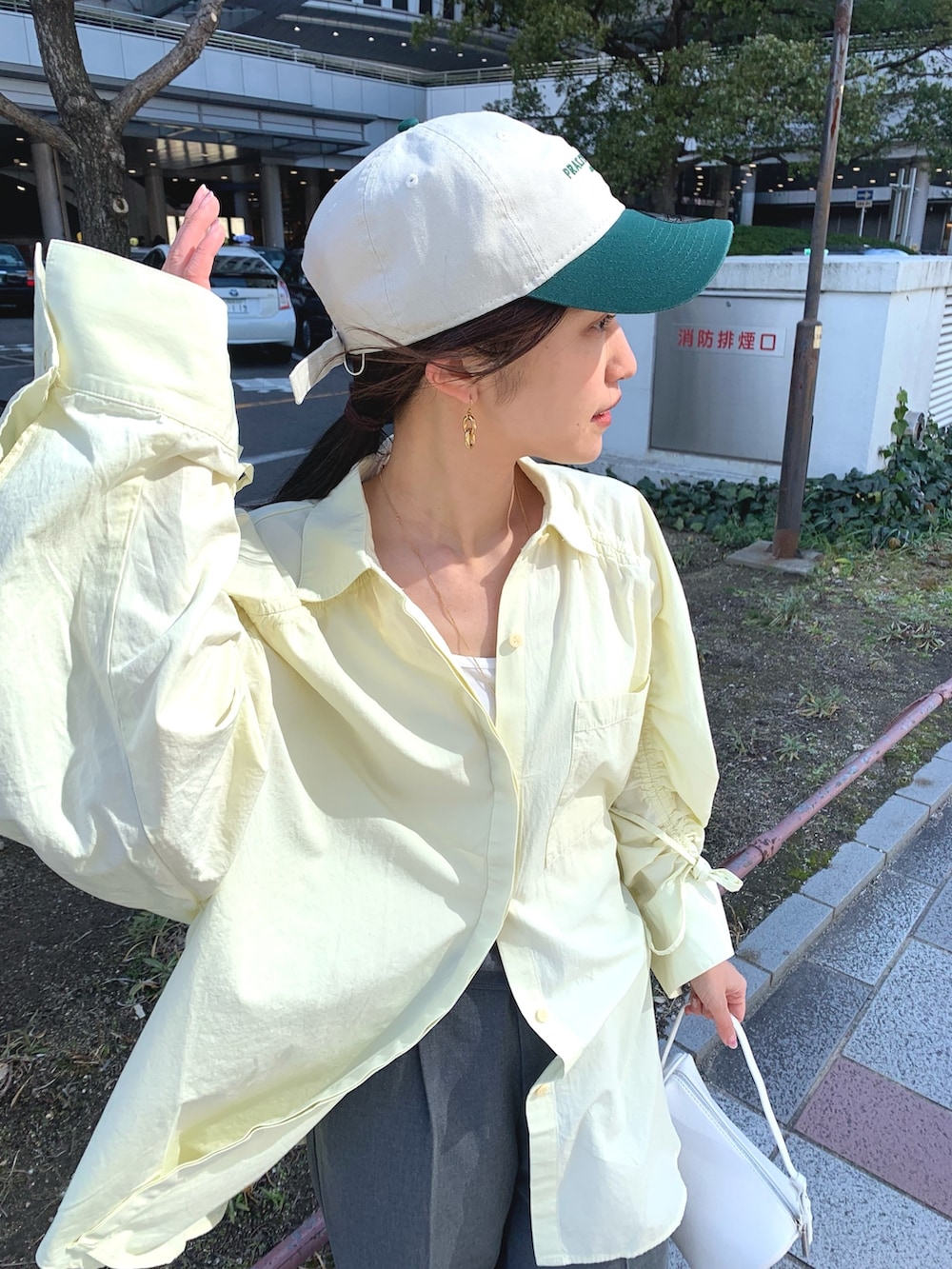 イエロー系のシャツ/ブラウス、グレー系のスラックス、ホワイト系のハンドバッグを着用したレディースの冬コーディネートの4枚目の写真