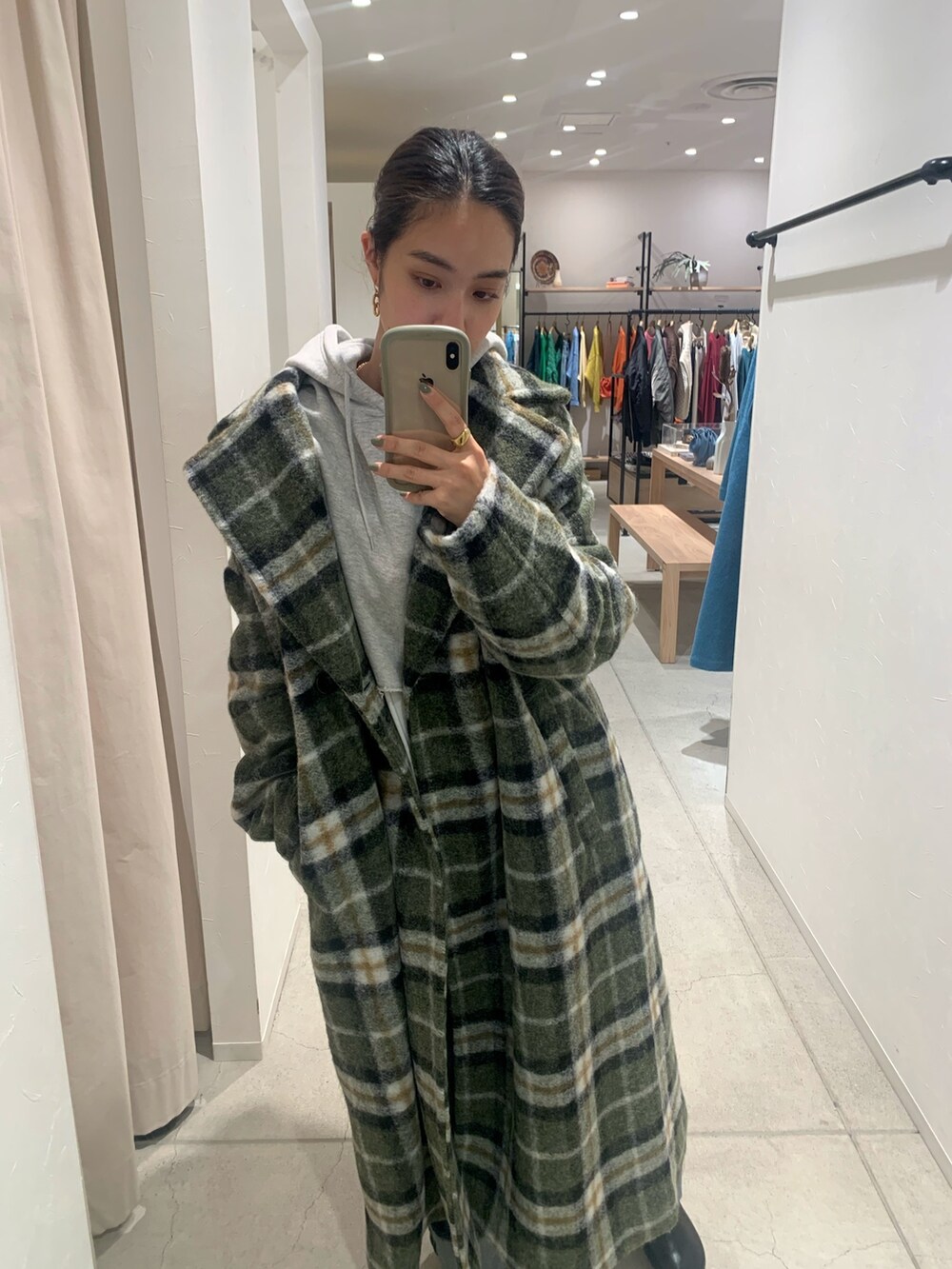 ブルー系のデニムパンツ、その他のチェスターコート、グレー系のパーカーを着用したレディースの秋コーディネートの5枚目の写真