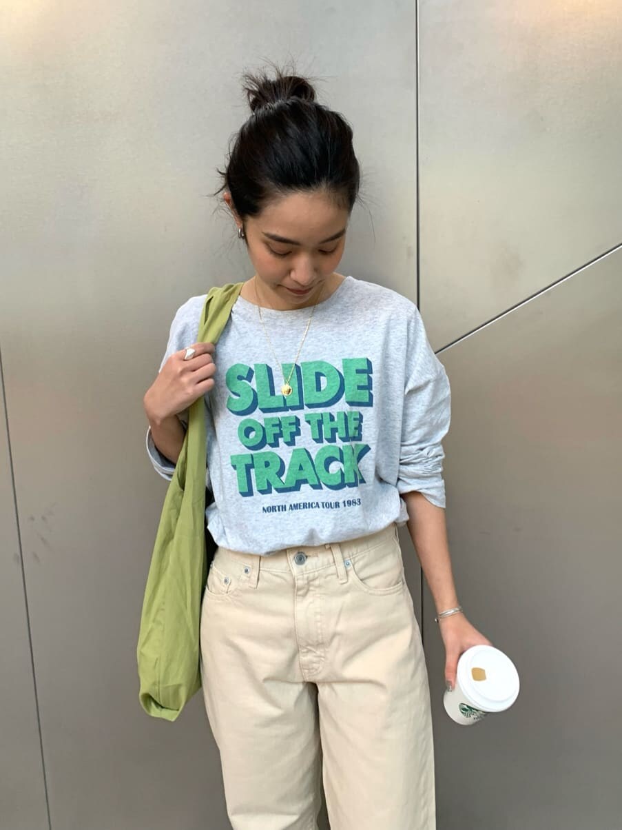 ベージュ系のステンカラーコート、ブラウン系のパンプス、グリーン系のエコバッグ/サブバッグを着用したレディースの冬コーディネートの3枚目の写真