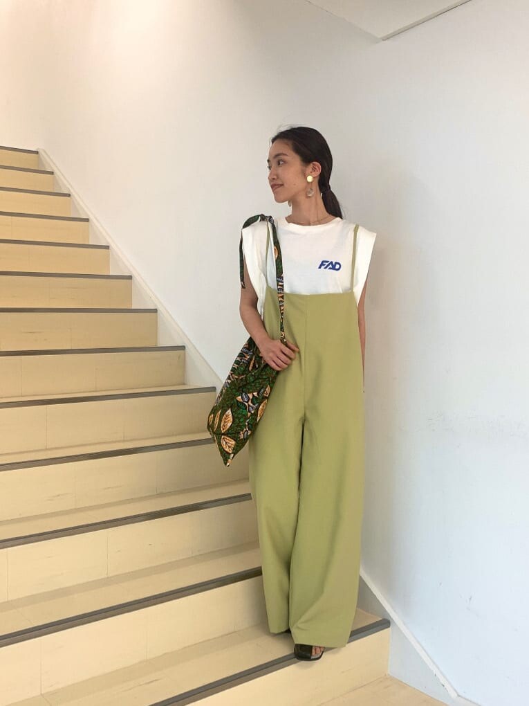 ブラック系のサンダル、ホワイト系のタンクトップ、グリーン系のショルダーバッグを着用したレディースの春コーディネートの2枚目の写真