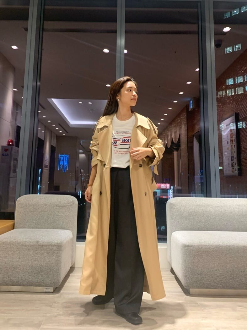 ベージュ系のトレンチコート、グレー系のスラックス、ホワイト系のTシャツ/カットソーを着用したレディースの秋コーディネートの4枚目の写真