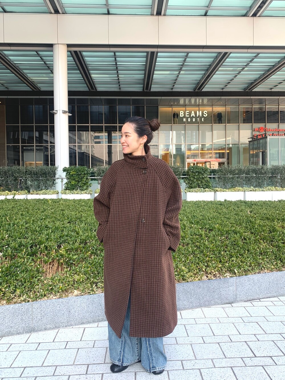 ブラウン系のその他アウター、グリーン系のニット/セーター、ブラック系のブーツを着用したレディースの冬コーディネートの2枚目の写真