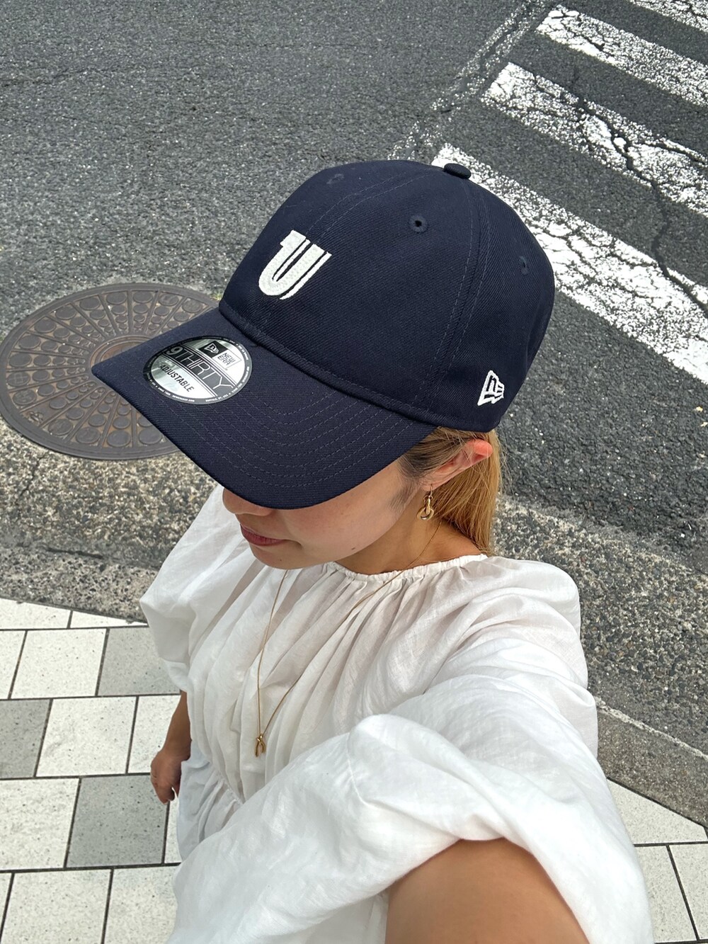 ホワイト系のシャツ/ブラウス、ブルー系のデニムパンツ、ブルー系のキャップを着用したレディースの夏コーディネートの7枚目の写真