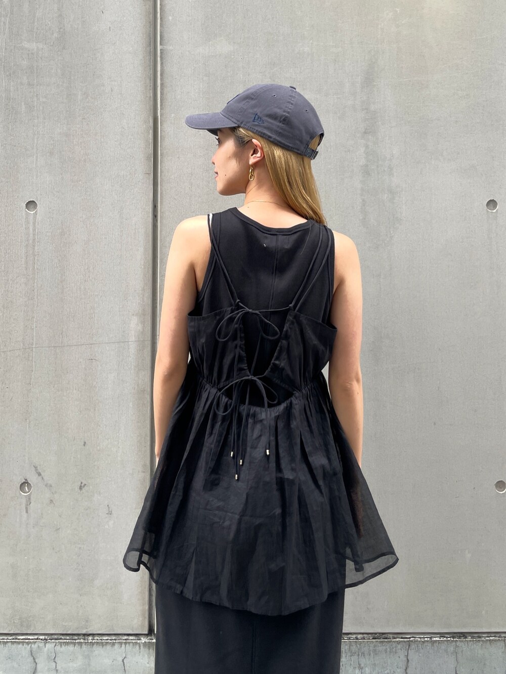 ブラック系のワンピース、ブラック系のキャミソール、シルバー系のサンダルを着用したレディースの春コーディネートの5枚目の写真