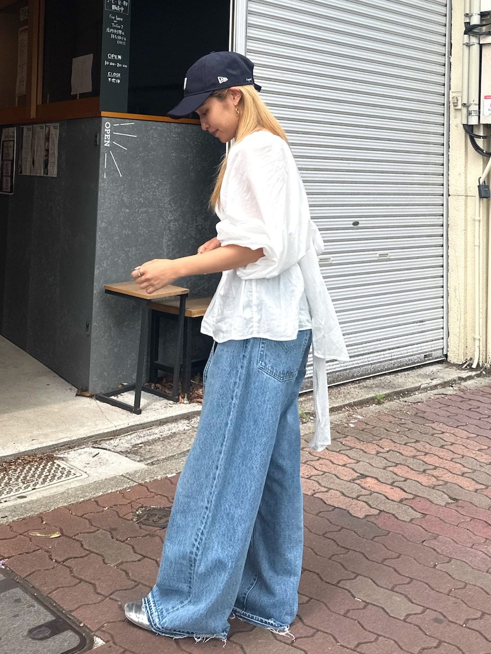 ホワイト系のシャツ/ブラウス、ブルー系のデニムパンツ、ブルー系のキャップを着用したレディースの夏コーディネートの3枚目の写真